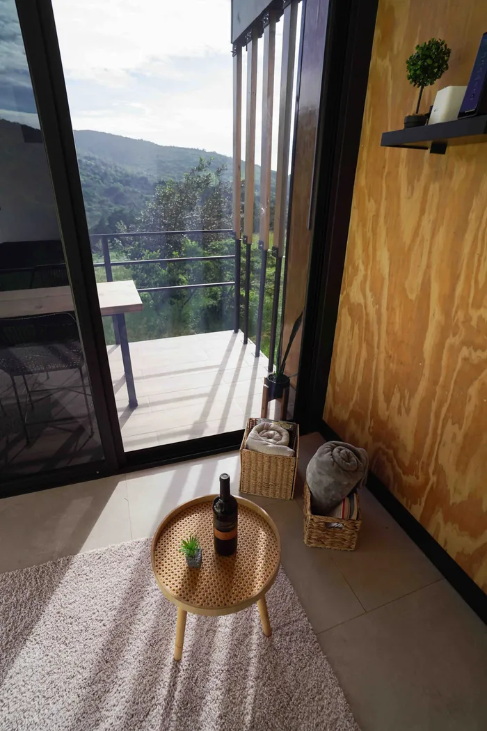 Mesita con una botella de vino junto al ventanal de la sala